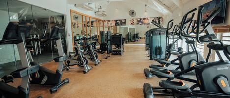 A gym with multiple treadmills, exercise bikes, and weight machines.