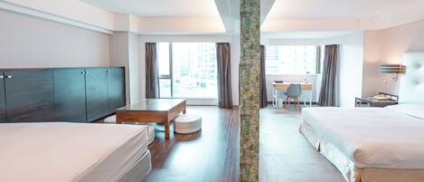 A modern hotel room with two beds, a desk, and a large window offering a city view.