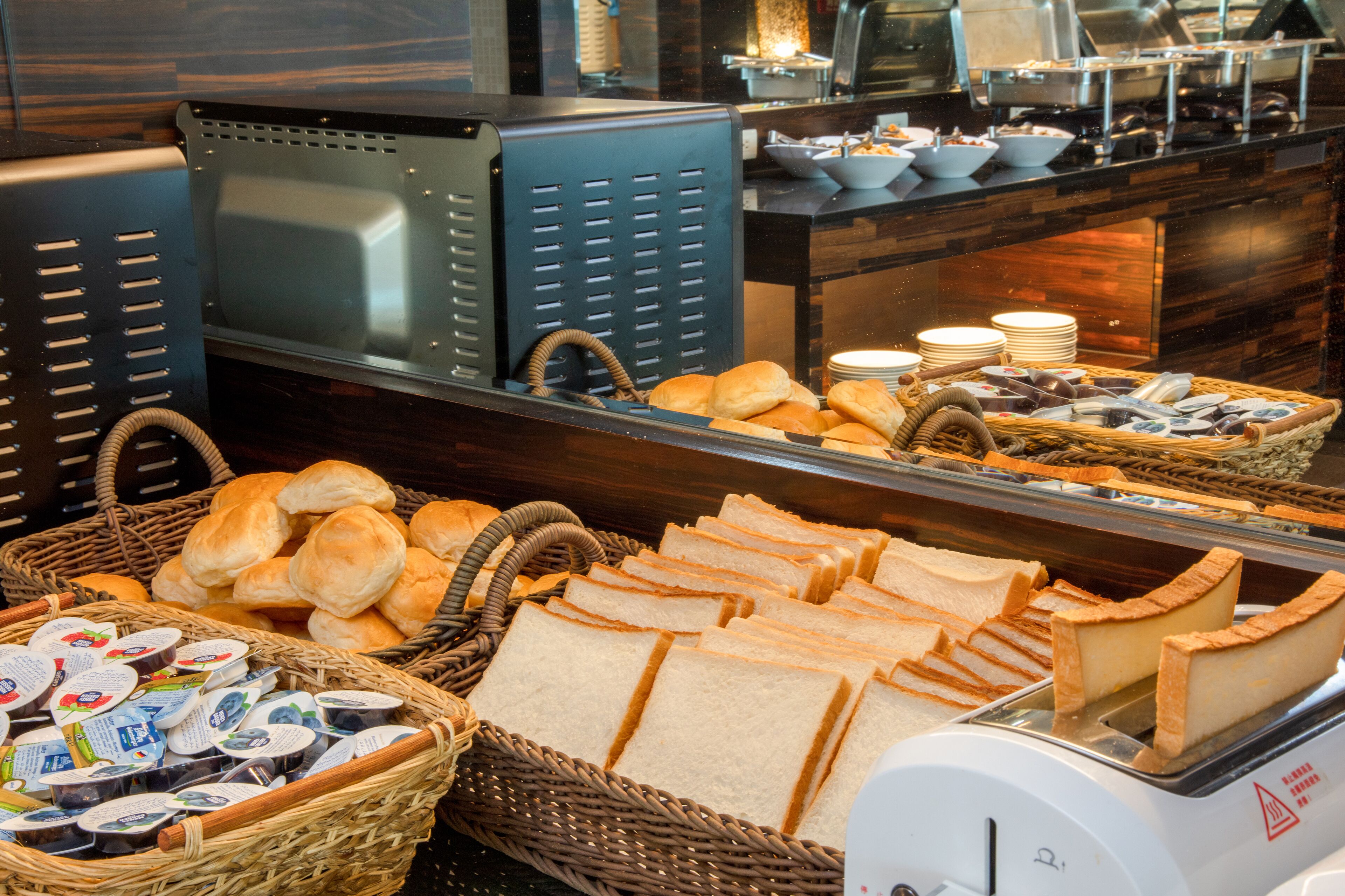 Ein Buffet mit verschiedenen Speisen, darunter Brot, Gebäck und Soßen.