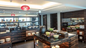 A modern kitchen with a buffet setup, including a central island with bowls and a large pot. - Hotel Cloud Riverside (New Taipei City)