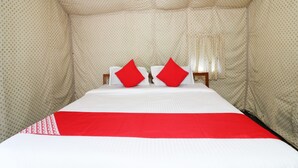 A room with a bed, pillows, and a patterned wall. - OYO 23439 Tapovan Heights Camp & Resort (Narendranagar)