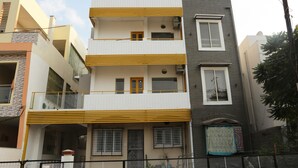 Un immeuble résidentiel à plusieurs étages, doté de balcons, d’une entrée sécurisée et d’une cour clôturée.