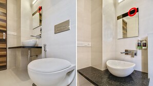 A modern bathroom with a white toilet, a sink with a marble countertop, and a mirror with a red frame. - OYO 29047 Yoyo Moonlight (Narendranagar)