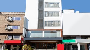 A multi-story building with a central vertical feature, large windows, and a flat roof. - Capital O 27658 Hotel New Mohit Regency (Bhopal)