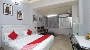 Habitación de hotel con una cama grande, una mesa de comedor y una kitchenette.