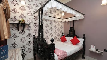 A four-poster bed with a white canopy, red pillows, and a red and white patterned bedspread.