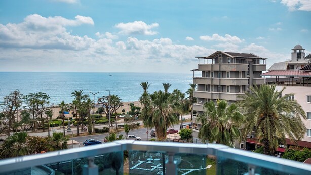 A hotel with a view of the beach and ocean, featuring a pool area and multiple floors. - Ustun Apart Hotel (Alanya)