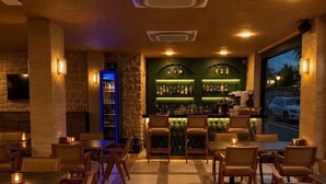 A bar area with a counter, shelves of bottles, and seating. - Ustun Apart Hotel (Alanya)