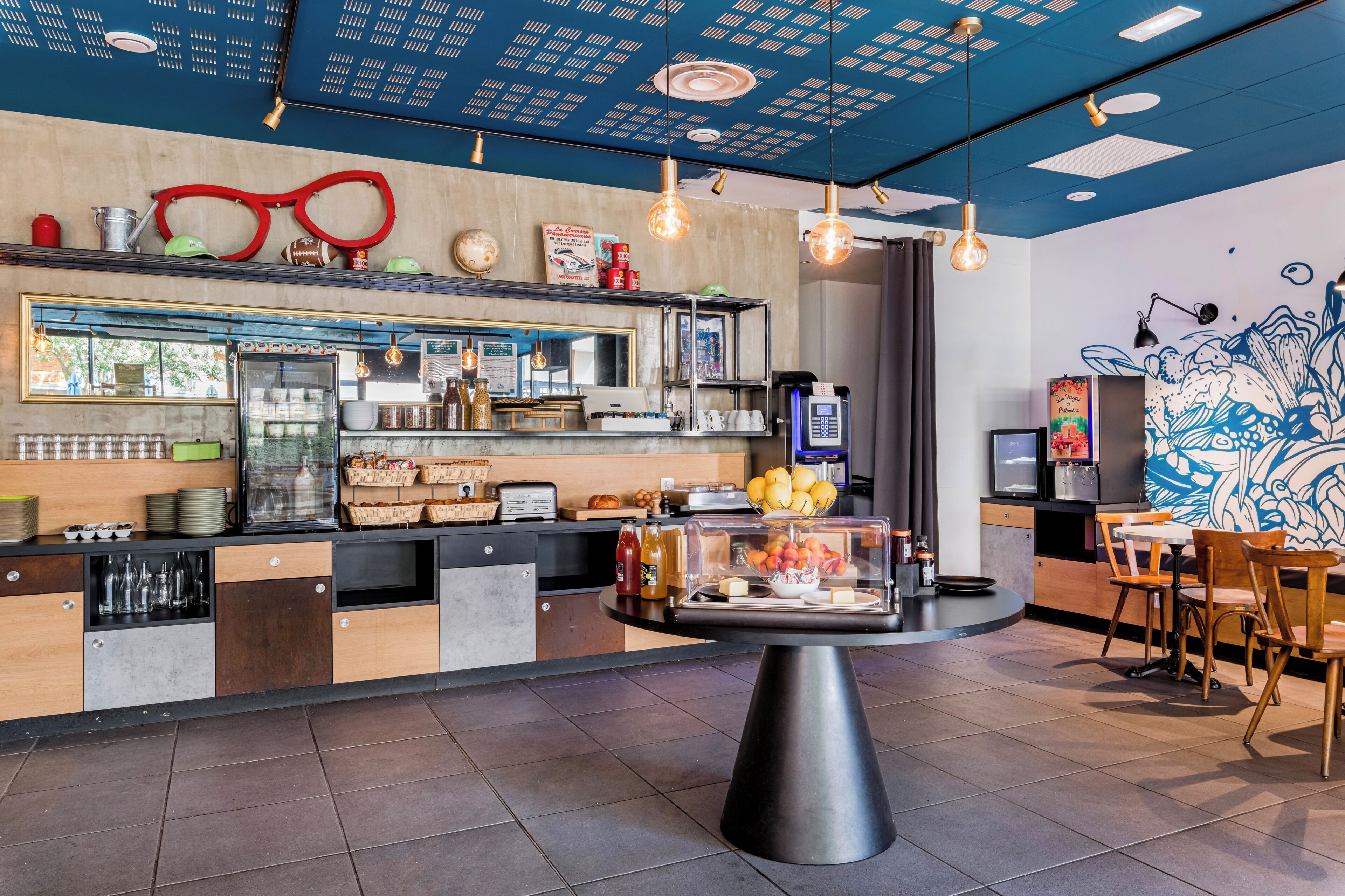L’intérieur d’un café moderne, avec un comptoir, un espace salon et des éléments décoratifs.