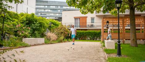 A gravel path in a landscaped area with greenery and a building in the background.