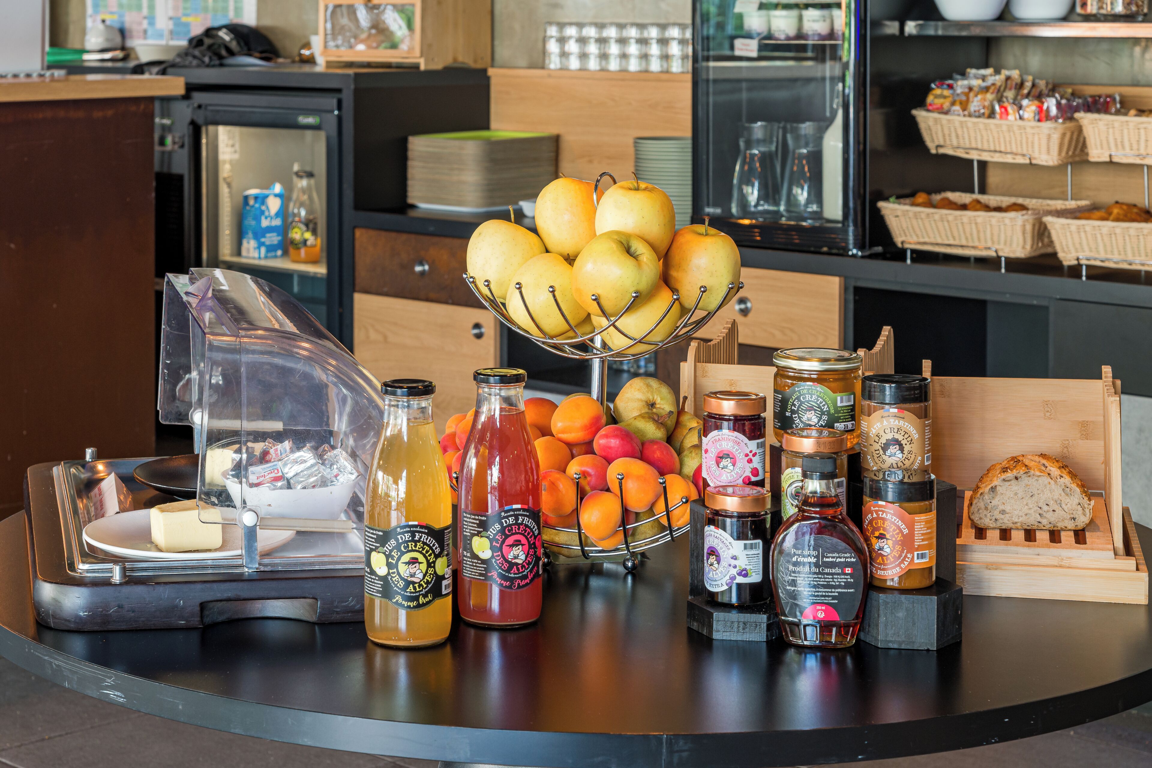 A breakfast buffet with fruits, jams, and bread.