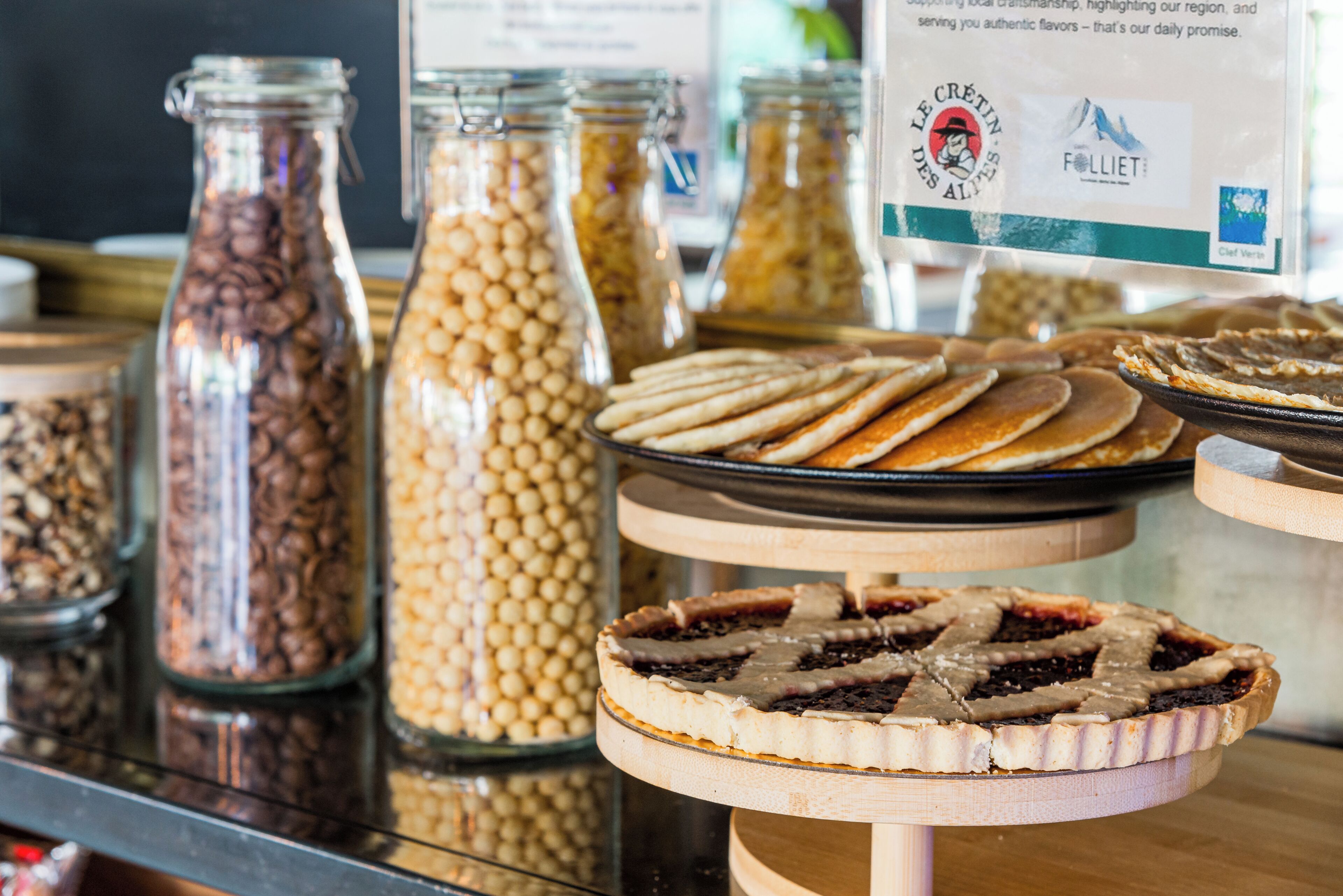 A variety of food items displayed in jars and on trays, including what appears to be cookies and a pie.