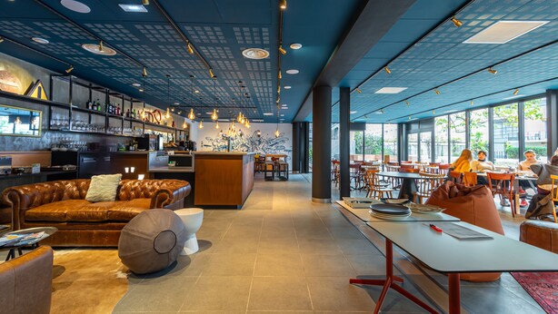 Un interior moderno con una zona de bar, asientos y una isla central.