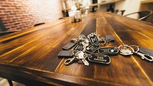 Una mesa de conferencia de madera con llaves y llaveros en el centro.