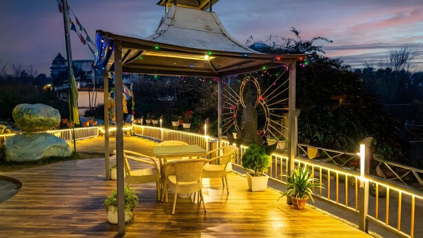 Eine Holzterrasse mit einem Gazebo, Topfpflanzen und einem Riesenrad.