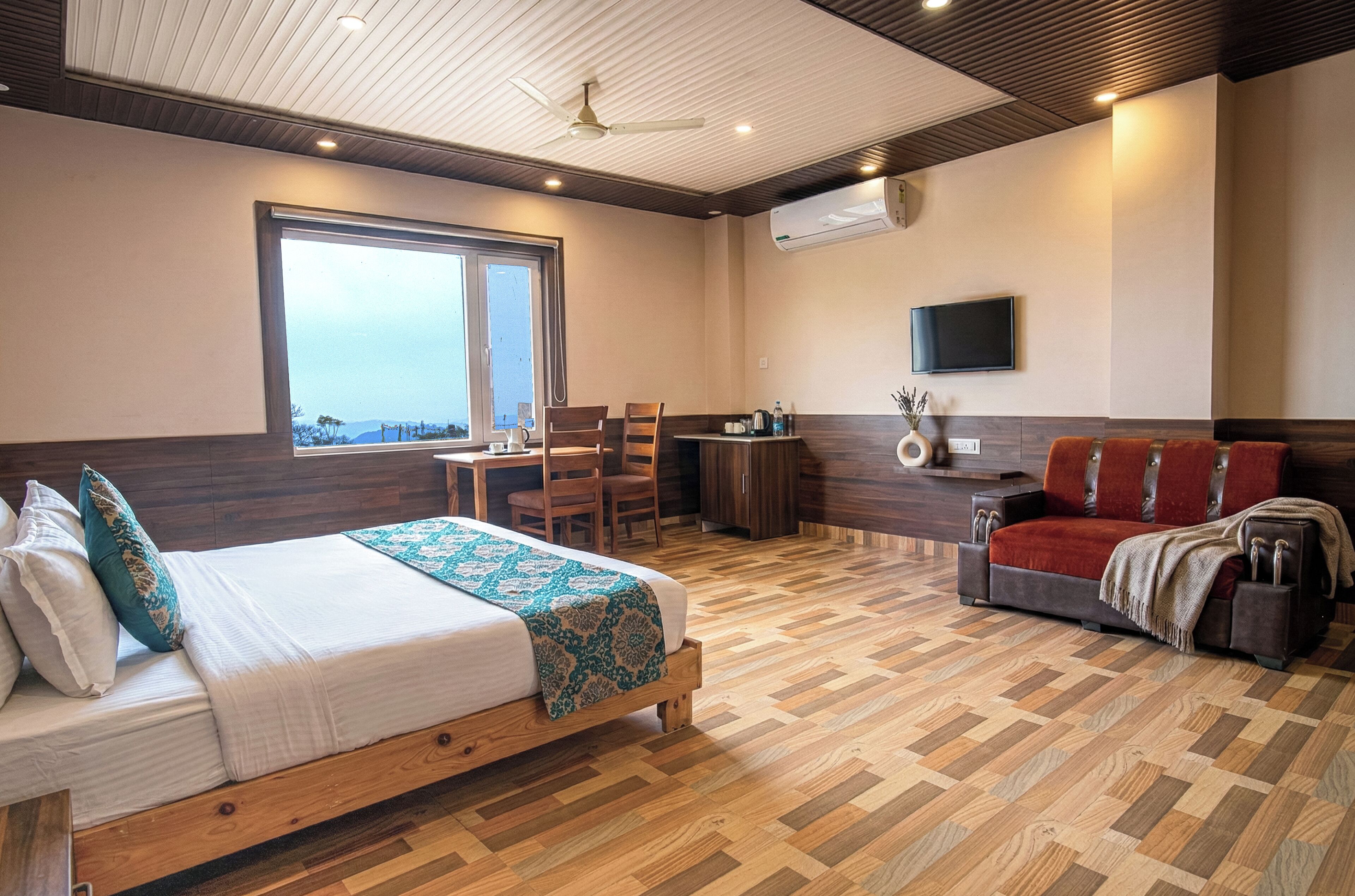 Een hotelkamer met een bed, bureau, televisie en een bank.