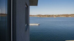 Vista desde una ventana sobre aguas tranquilas y una costa lejana.
