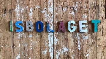 Ordet ”ISBOLAGET” skrivet med färgglada bokstäver mot en träbakgrund.