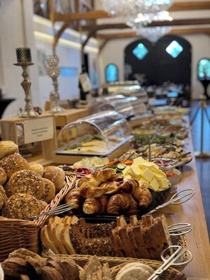 A buffet with various breads, pastries, and cheeses. - Ferienwohnungen Ludgerushof (Bocholt)