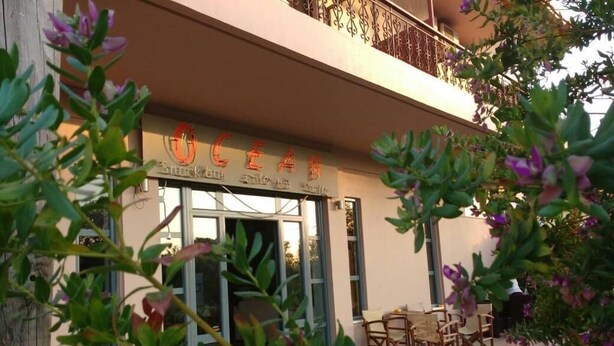 A snack bar with outdoor seating and a balcony. - Ocean-Pacific (Pyrgos)