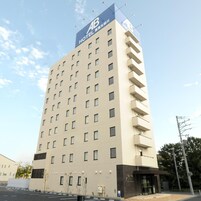 Edifício de hotel com vários andares e um letreiro grande 'AB HOTEL' no topo.