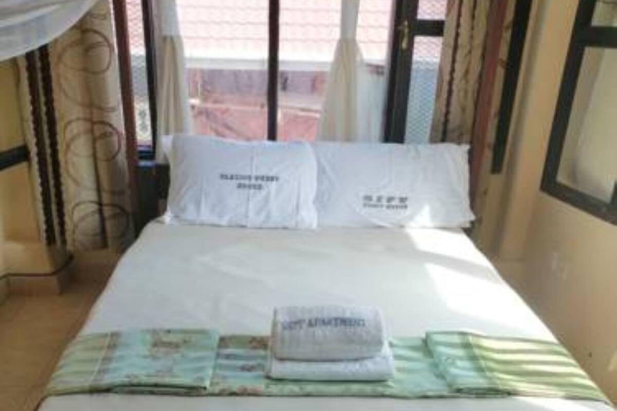 Ein Bett mit einer weißen Matratze, einer gefalteten Decke und einem Kopfkissen mit Text.