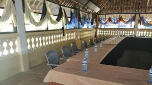 A conference room with a long table, chairs, and water bottles. - Diani Gift Guest House (Diani Beach)