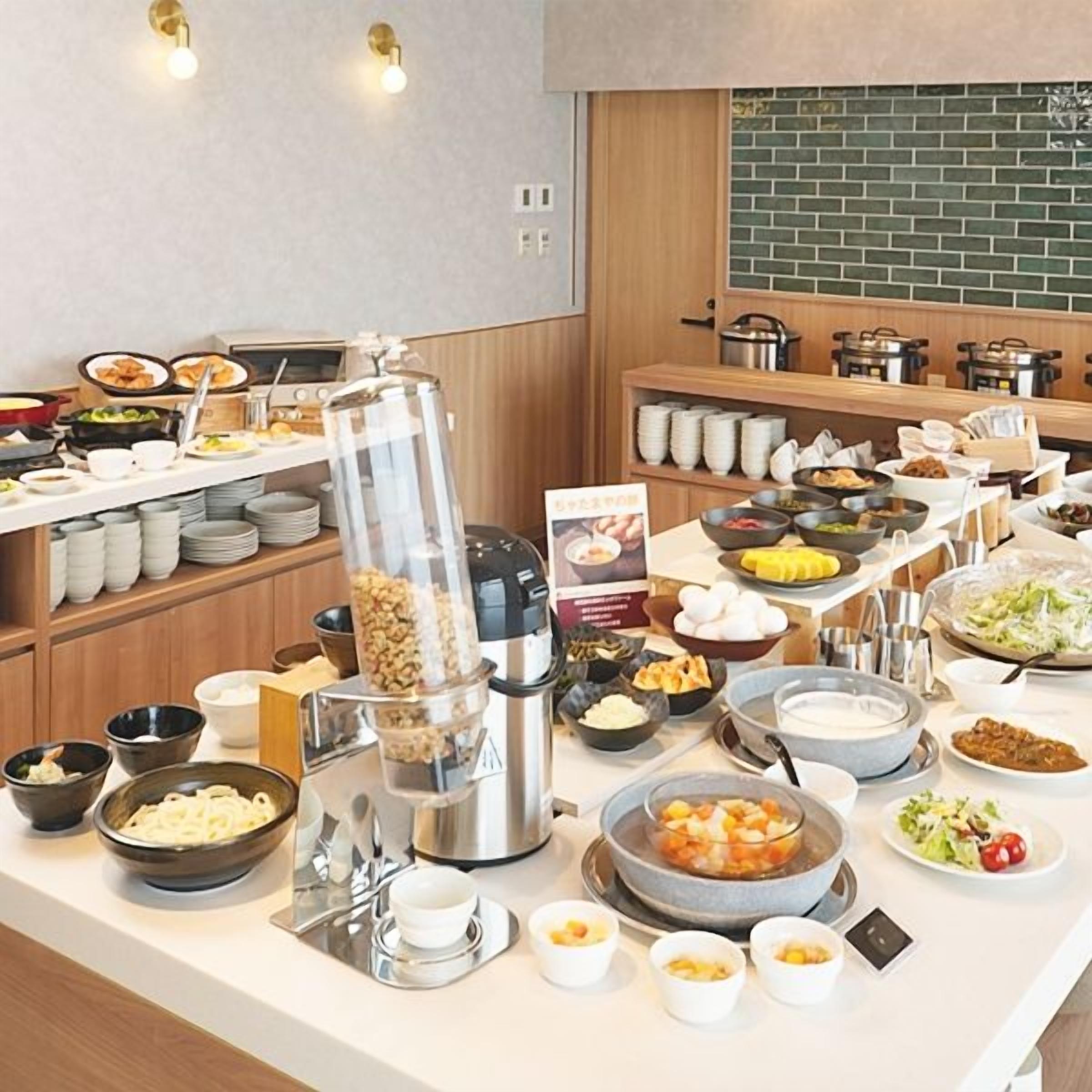 A buffet setup with various food items and a coffee machine.
