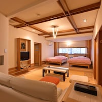 Una habitación de hotel moderna con sofá, dos camas, televisor y ventana con vistas.