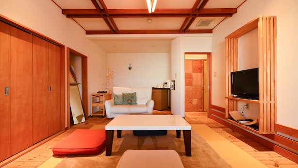 A room with a sofa, a table, a TV, and wooden cabinets. - Ikaho Onsen Akari No Yado Okabe (Shibukawa)
