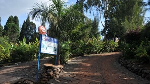 Señal del Hotel Kinturfalls con un sendero que atraviesa un jardín.