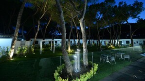 An outdoor area with trees, a glass fence, and outdoor seating. - Homeholiday Giulivo (Cellole)