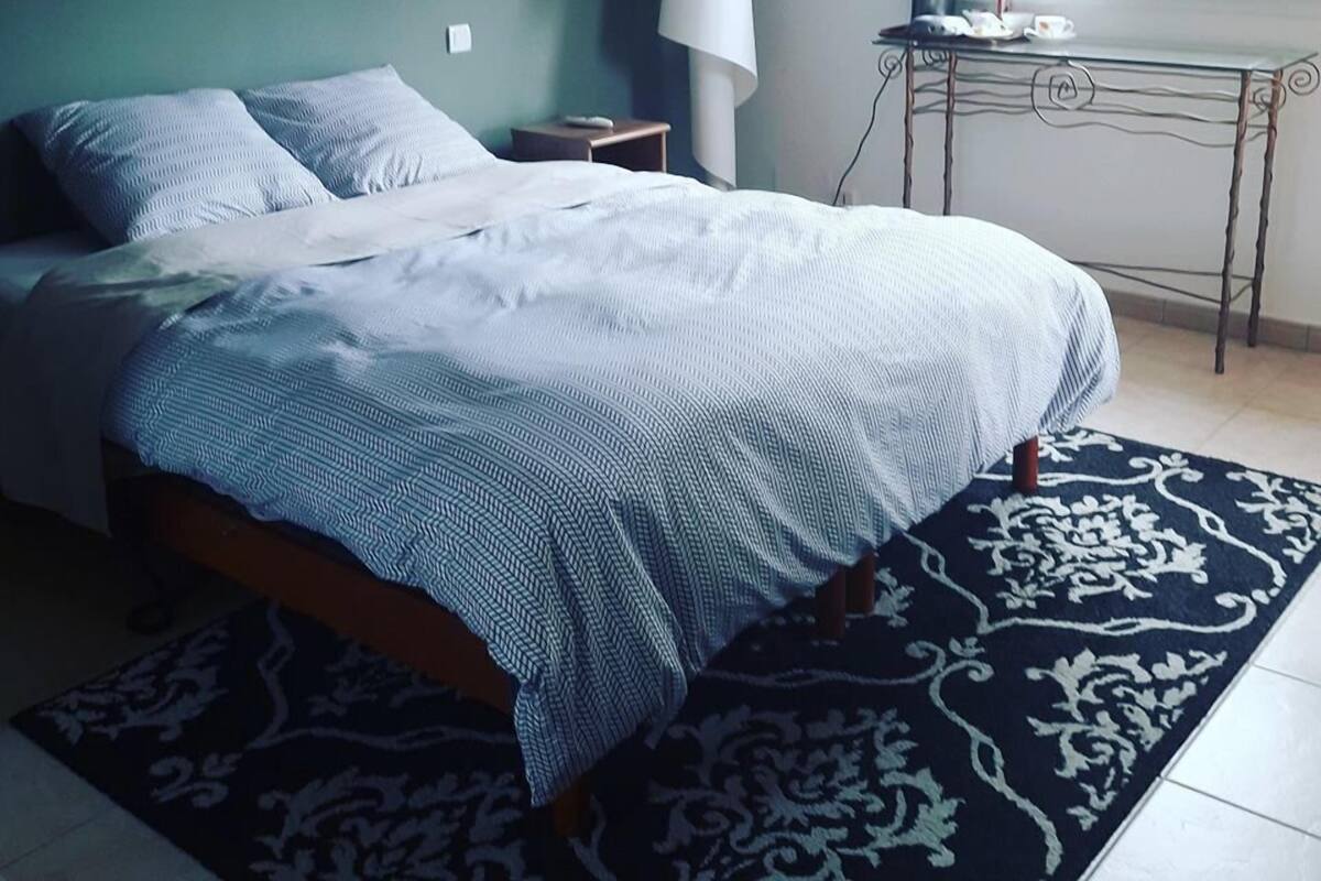 Un dormitorio con cama, escritorio y ventana.