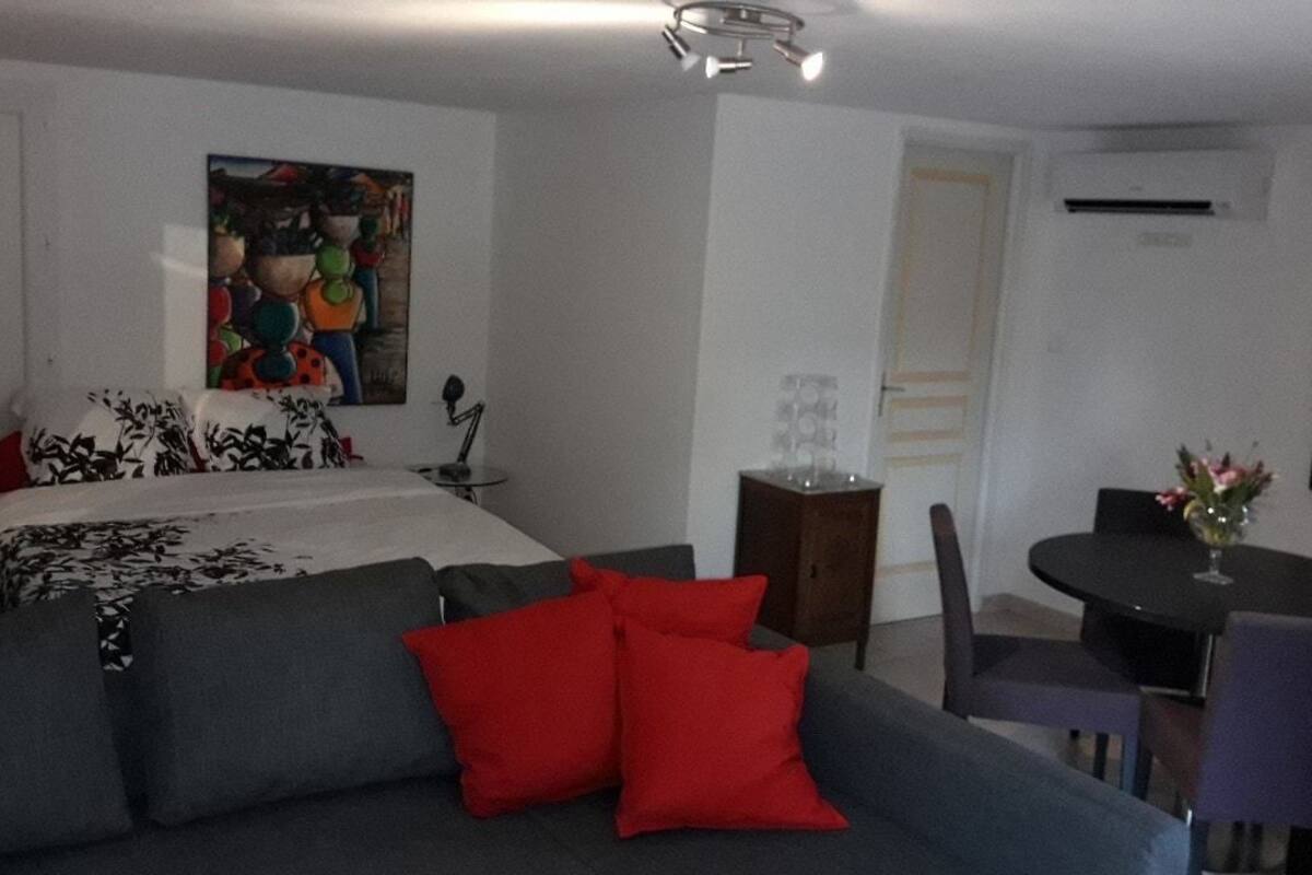 Un dormitorio moderno con cama, sofá, mesa de comedor y una silla.