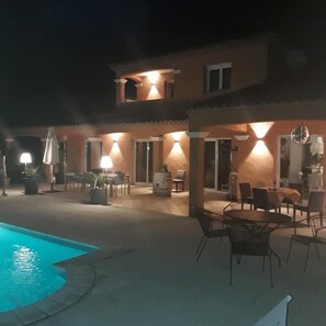 Vista frontal de la propiedad por la tarde o noche