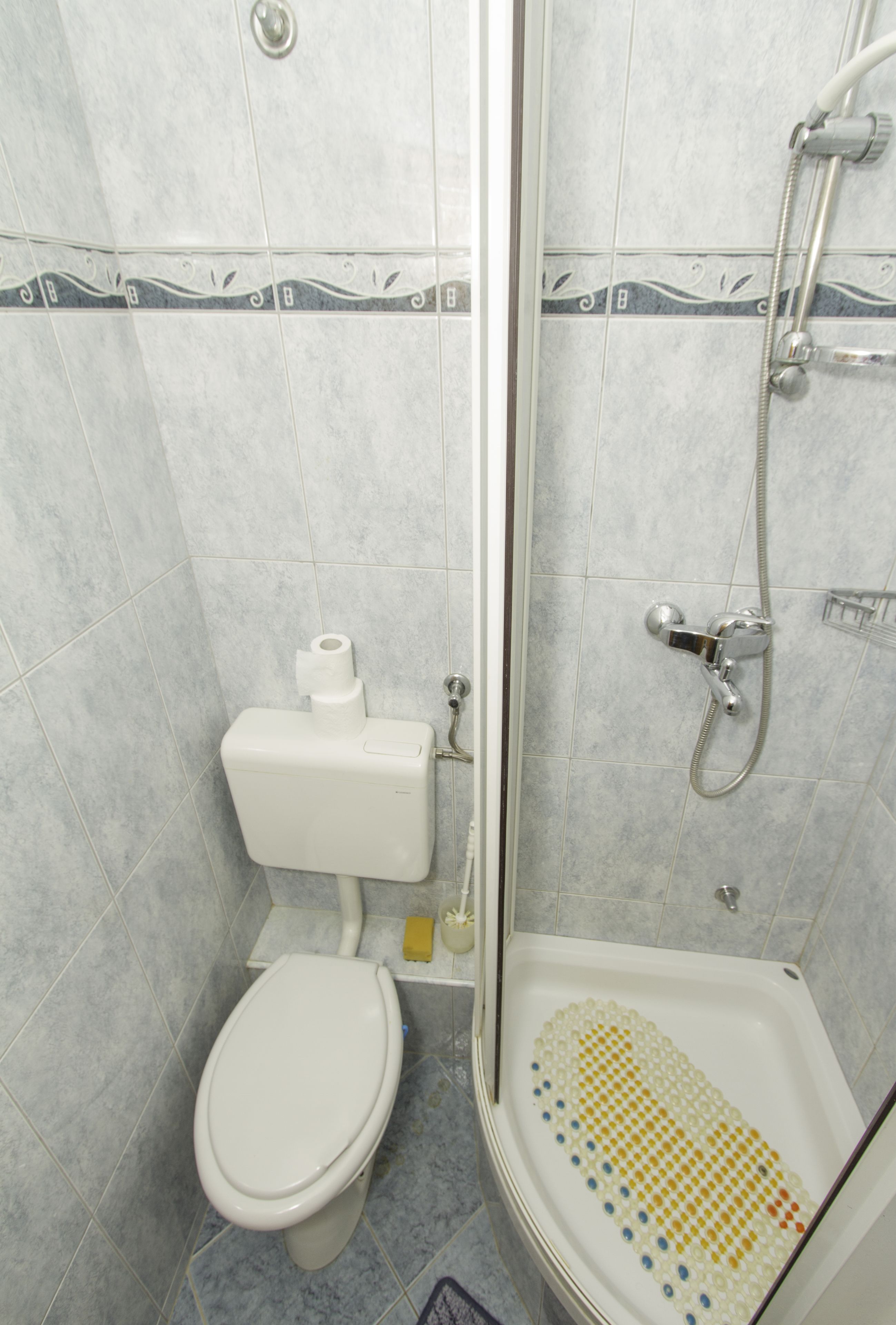 A bathroom with a toilet, a shower, and a bidet.