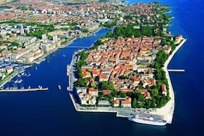 An aerial view of a coastal town with a marina, historic buildings, and a prominent church. - Apartments Joso (Zadar)