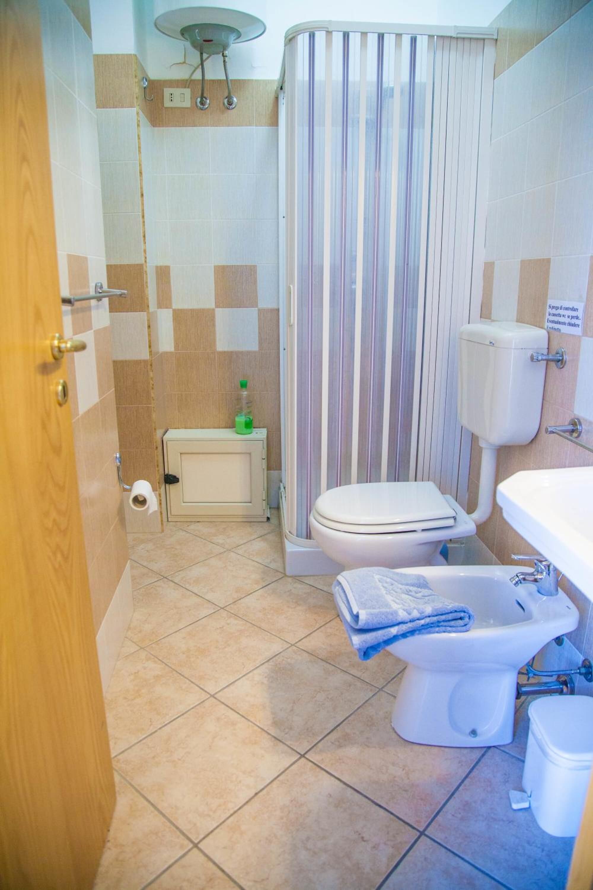 A bathroom with a toilet, bidet, and sink.