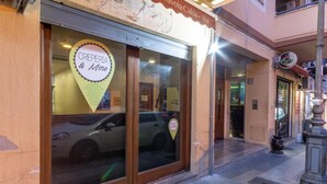 A storefront with a sign that reads "CREPERIA & More" and a parked car outside. - B&B Il Castellino (Santo Stefano di Camastra)