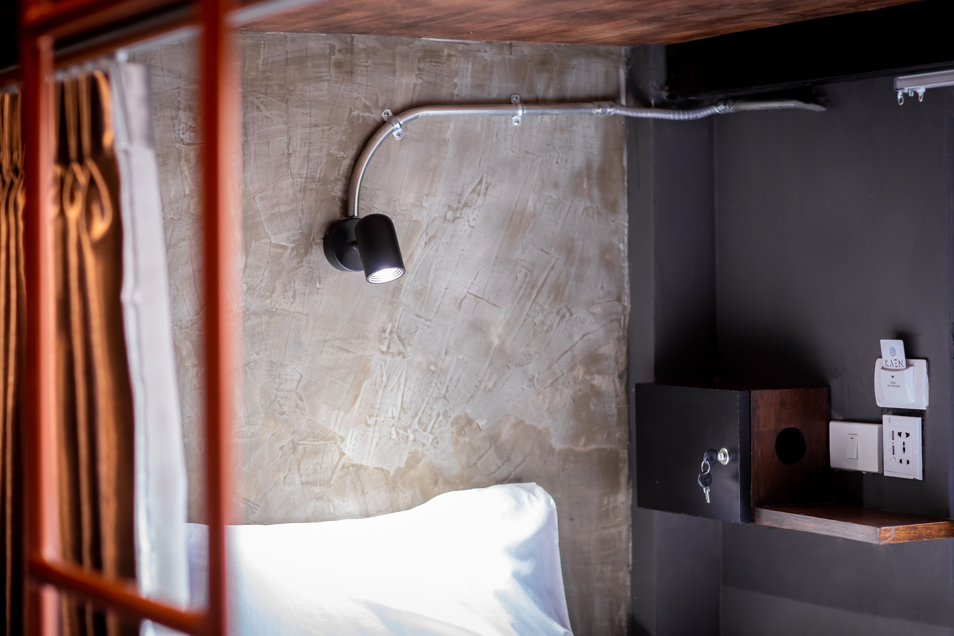 Un baño moderno con suelo de concreto, estante de madera con artículos de tocador, toallero y ducha.