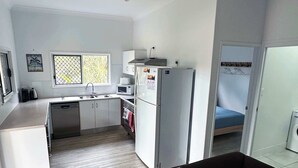 A compact living space with a kitchenette, a ceiling fan, a sofa, and a window with a view. - Ohana Hawaiian term meaning "family" (Agnes Water)
