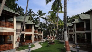 A resort with multiple bungalow-style buildings, each with a balcony and a tiled roof. - Sandyy Wavess Beach Resort (Port Blair)