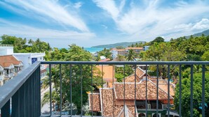 A coastal town with traditional buildings, a clear sky, and a view of the sea. - KK - Karon Kata Boutique Hotel (Karon)
