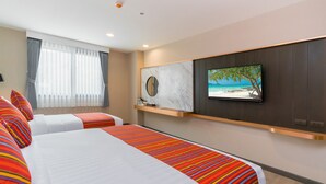A hotel room with two beds, a TV mounted on the wall, and a window with curtains. - KK - Karon Kata Boutique Hotel (Karon)