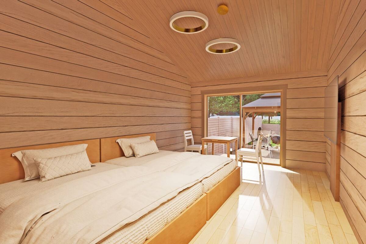 A wooden room with a bed, a table, and chairs.