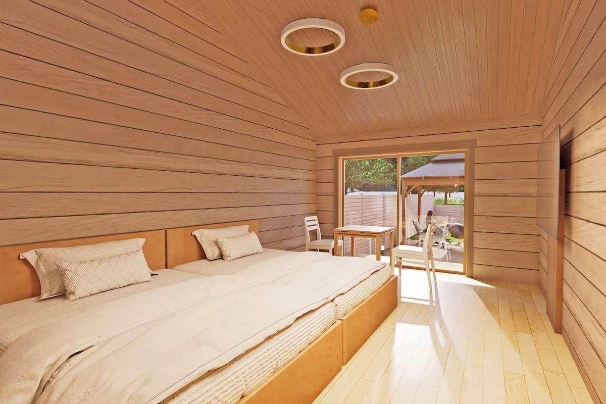 A wooden room with a bed, a table, and chairs.