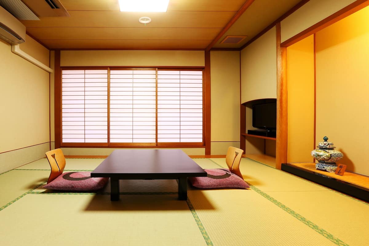 A traditional Japanese room with tatami flooring, a low table, and shoji screens.