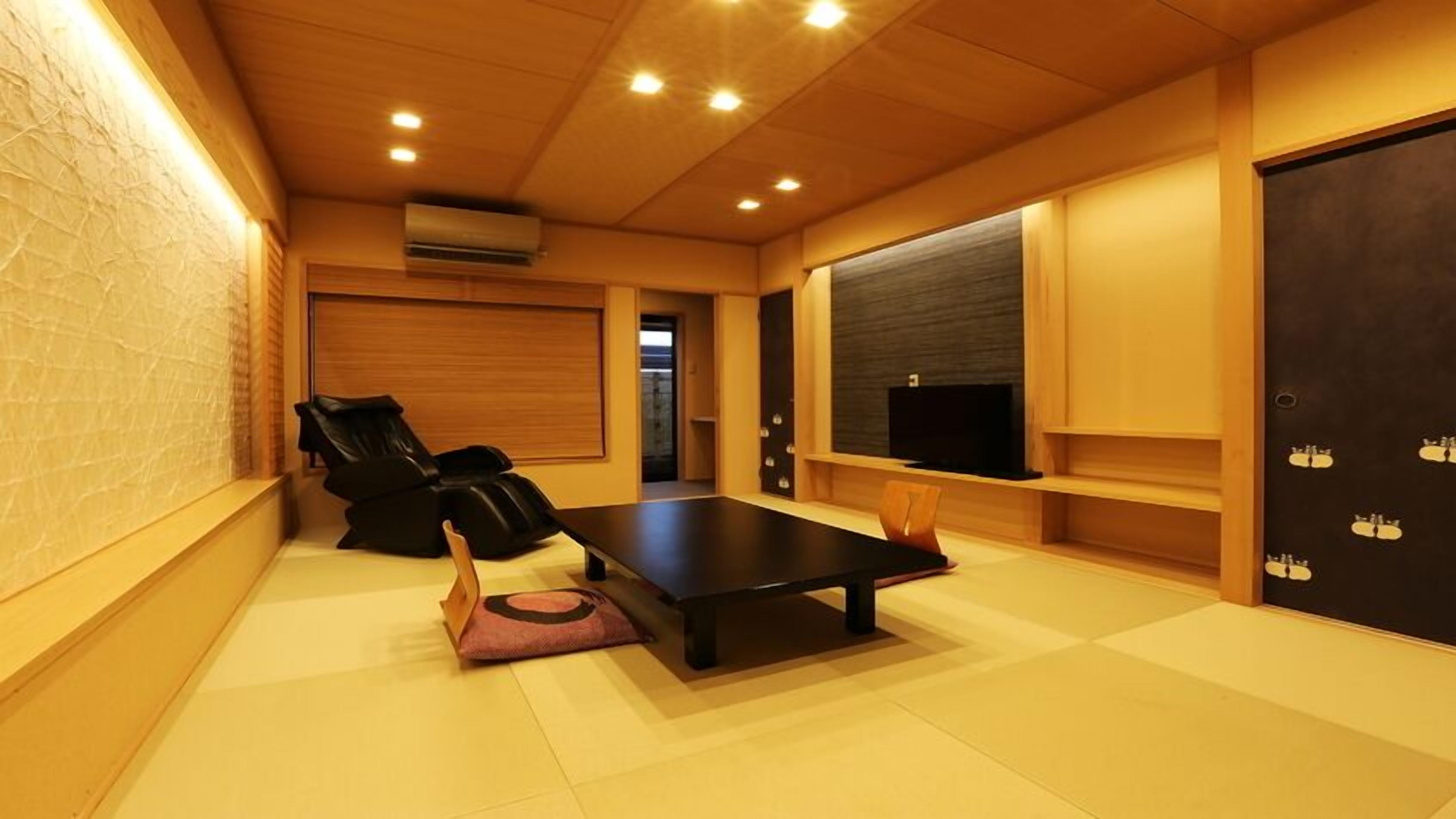 A room with a massage chair, a flat-screen TV, and a wooden floor.