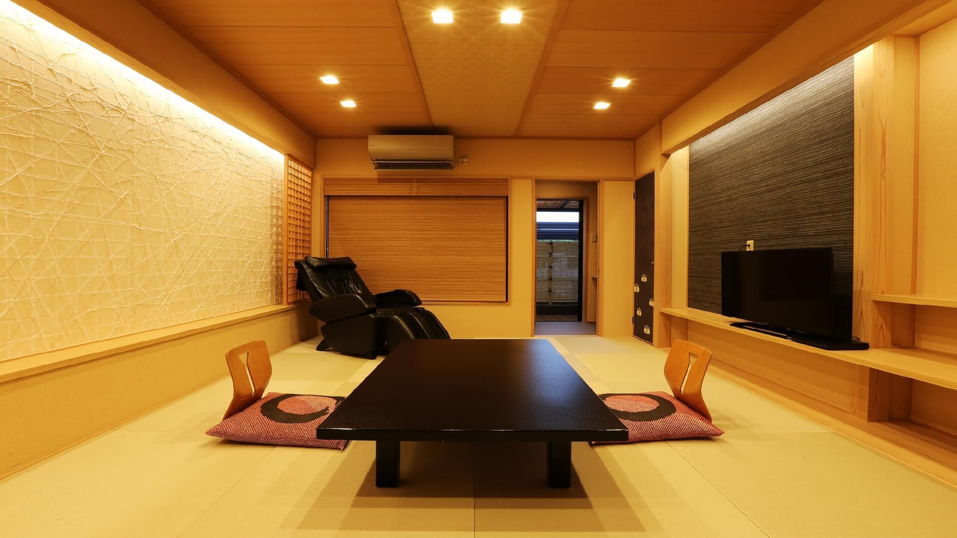 A conference room with a long table, chairs, a television, and a sliding door.
