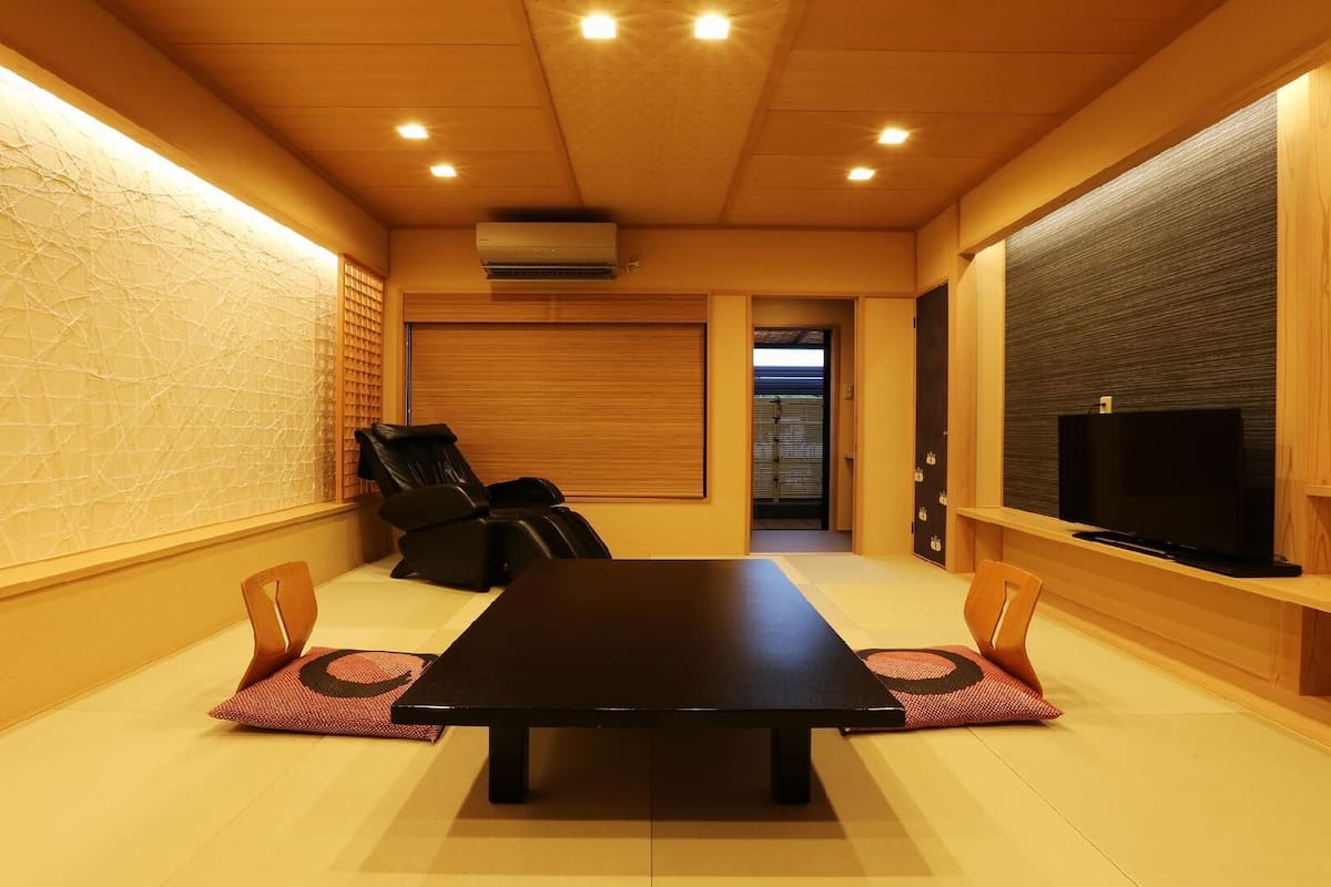 A conference room with a long table, chairs, a television, and a sliding door.